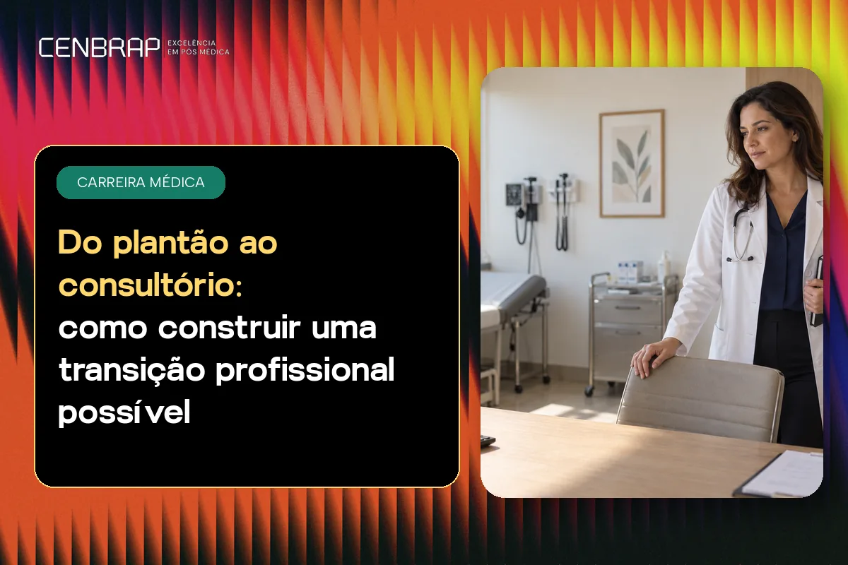 Médica de jaleco em pé, sorrindo, no consultório com maca, mesa e equipamentos ao fundo.